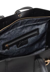 Černá kožená kabelka uvnitř se zlatým zipem, šedým vzorovaným podšívkou a černou kapsou na zip s logem značky. Dvojité uši nahoře.