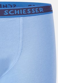 Boxer shorts in cotone azzurro chiaro con una texture a coste. Presentano un elastico in vita di colore blu scuro con il logo "SCHIESSER" ricamato in blu.