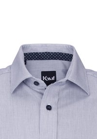 Camicia a scacchi blu e bianca con colletto a punta, chiusura frontale con bottoni scuri e fodera interna del colletto a fantasia blu navy.