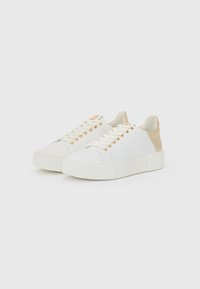 Weiße Sneakers mit beigen Fersenakzenten, ausgestattet mit goldenen Ösen, einer strukturierten Gummisohle und einem glatten Textil-Obermaterial.