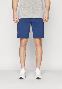 Blue shorts made of lightweight fabric, featuring a straight cut and no visible patterns, paired with white sneakers.