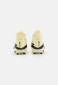 Scarpe da calcio gialle con design a caviglia alta, accenti neri e superficie testurizzata. Dotate di un inserto sul tallone per una facile calzata.