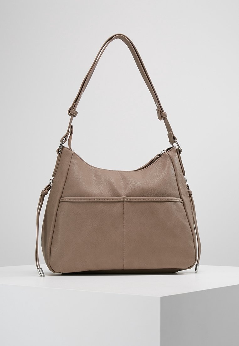 Borsa a spalla in pelle taupe con tracolla regolabile, tasca frontale aperta e chiusura con cerniera, esposta su un piedistallo bianco.