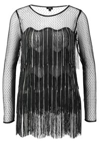 Haut en mesh noir avec un motif à pois, manches longues et un détail de franges à l'ourlet, créant un effet de texture superposée.