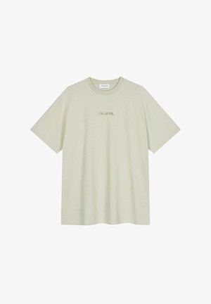 Gai beigā kokvilnas t-krekls ar apaļu kakla izgriezumu un īsām piedurknēm, kas priekšpusē rotāts ar tekstu "OH APRIL" plānā fontā.