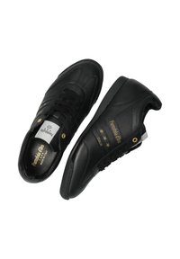 Černé kožené tenisky s hladkým povrchem, mají perforovanou boční část, zlaté akcenty a šněrovací design. Součástí jsou dva vzory hvězd.