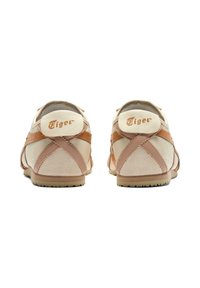White and light pink athletic shoes with suede and leather materials, featuring a vintage design, striped accents, and a logo at the heel.