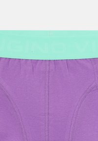 Boxers roxos com um tecido macio, uma cintura azul clara com texto em relevo e costura em contraste ao longo das bordas.