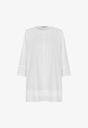 Tunique blanche avec un encolure ronde, un bouton sur le devant, des manches trois-quarts avec des accents en œillets et une coupe décontractée. Texture de tissu douce.