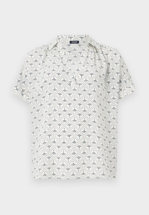 Blouse blanche à manches courtes avec un motif géométrique noir, dotée d'un col et d'une coupe ample. Fabriquée en tissu léger.