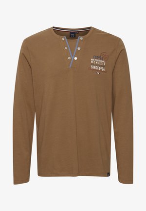 Cămașă maronie cu mânecă lungă, fabricată din bumbac, având un guler cu nasturi, cusături albastre, și detalii imprimate în alb și roșu.