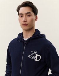 Felpa con zip di colore blu navy, dotata di un cappuccio con cordino e logo "LD" bianco sul lato sinistro del petto. Tessuto morbido con una texture liscia.