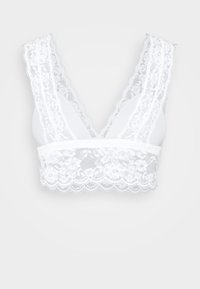 White lace bralette featuring a deep V-neck, wide lace straps, scalloped edges, and floral lace detailing on the band. Soft fabric composition.