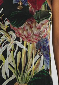 Sukienka z materiału w kwiatowy wzór, charakteryzująca się żywymi kolorami, w tym czerwonymi, zielonymi i żółtymi. Tekstura z elastycznym marszczeniem w talii.