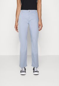 Jasnoniebieskie spodnie z mieszanki bawełny, z prostym krojem, kieszeniami z przodu oraz zapięciem na srebrny guzik. W połączeniu z czarnymi sneakersami.