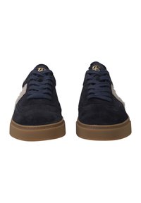 Sneaker in camoscio blu navy con accenti color crema, punta arrotondata e suola in gomma marrone testurizzata. Presenta lacci blu navy e dettagli con logo dorato.