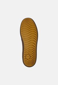 Rubber outsole with a wavy texture, brown edges, and a circular logo. Size 42 marked on the upper surface.