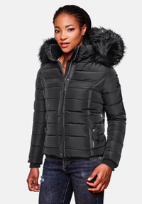 Black puffer jacket with a detachable faux fur hood, quilted design, zippered pockets, and ribbed cuffs. Worn with dark denim jeans.