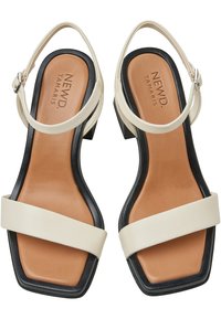 Crème leren sandalen met een brede band over de tenen en een enkelbandje. Vierkante neus en chunky zwarte hak. Het interieur beschikt over een beige binnenzool met merklogo.