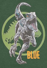 La camiseta presenta un gran gráfico de un dinosaurio con escamas detalladas, acentos azules y la boca abierta. El texto "AZUL" está en negrita naranja.