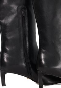 Black leather ankle boots with a low, square heel and side zipper detail. Smooth texture and sleek design with a fitted silhouette.