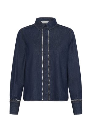 Camicia di denim blu scuro con colletto, dotata di una pattina frontale decorata con borchie argentate e polsini borchiati. Maniche lunghe con polsini abbottonati.