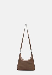 Bolso de hombro de cuero marrón con forma curva, correa ajustable y superficie texturizada, que presenta elementos de diseño minimalistas y sin hardware visible.
