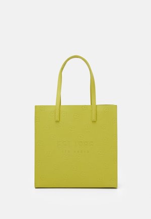 Sac fourre-tout carré jaune avec deux poignées, motifs floraux en relief et texte "EST. 1988 TED BAKER" sur le devant.