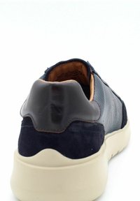 Sneaker blu navy con parte superiore in camoscio e rete, tacco lucido a contrasto, suola crema e dettagli testurizzati sui lati.