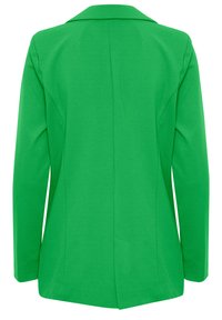 Blazer verde con una tela suave, de mangas largas y con cuello de muesca. Presenta una abertura en la parte trasera y una silueta entallada.