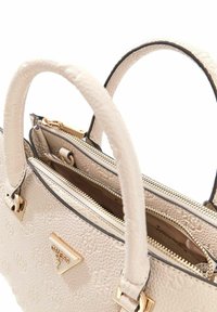 Borsa a tracolla in pelle beige con finitura texturizzata, doppie maniglie superiori, ferramenta color oro e scomparti con zip. Presenta l'emblema del marchio sul davanti.