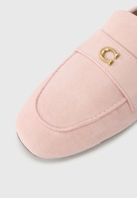 Ροζ μοκασίνι από σουέτ με στρογγυλεμένη μύτη, διακοσμημένο με χρυσή λεπτομέρεια στο λουράκι και διακριτικές ραφές. Ομαλή υφή.