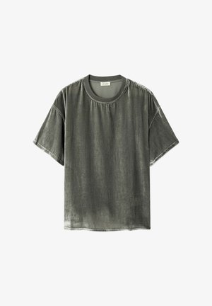 T-shirt gris à manches courtes et col rond avec une texture légèrement délavée et usée, et des coutures visibles sur les épaules et les manches.