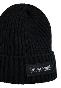 Zwarte gebreide beanie met verticale ribbels, voorzien van een stoffen label met de merknaam "bruno banani" en de tekst "NIET VOOR IEDEREEN."