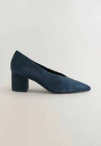 Mornarsko modra semiš čevlja s peto, z uskim nosom in masivno blok peto. Gladka tekstura, eleganten dizajn in minimalni detajli.