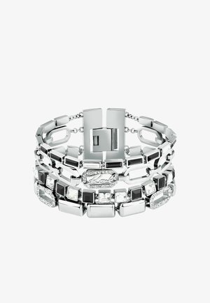 Bracciale a tre strati in metallo tono argento, con collegamenti rettangolari alternati, gemme nere e bianche, e una chiusura a gancio con dettaglio del logo.