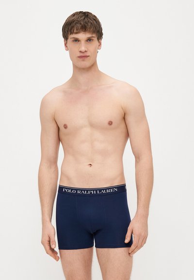 Granatowe bokserki o dopasowanym kroju z elastycznym pasem w talii, na którym znajduje się logo "POLO RALPH LAUREN" w kontrastowym kolorze.