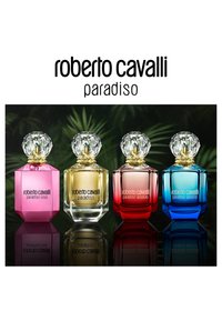 Cuatro botellas de perfume Roberto Cavalli Paradiso en rosa, dorado, rojo y azul con tapas facetadas transparentes sobre una superficie reflectante.
