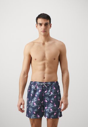 Bañador de color navy con un patrón de flamencos y palmeras. Fabricado en material ligero, cuenta con una cinturilla elástica y cordón ajustable.