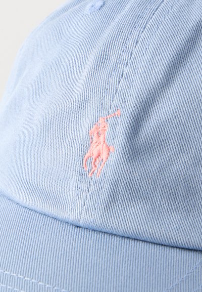 Καπέλο από ανοιχτό μπλε ύφασμα με μικρό ροζ κεντημένο σχέδιο παίκτη πόλο επάνω σε άλογο κοντά στο κέντρο εμπρός.