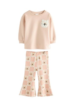 Roze sweatshirt met berenapplicatie op de borst, gecombineerd met flared broek met berenhoofdpatroon in vierkanten, ribbelstructuur, zachte stof.