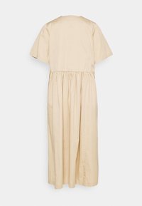 Vestido de algodón beige con un corte relajado, mangas cortas, cintura fruncida y una falda fluida hasta la rodilla. Sin patrones ni adornos visibles.