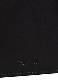 Calvin Klein black leather wallet with a smooth texture, subtle stitching, and embossed logo, featuring a rectangular shape.