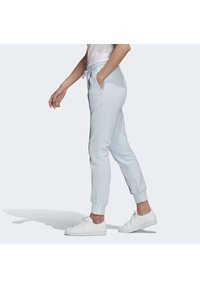Ljusblå sweatpants med elastisk midja, sidofickor och ribbade mudd. Har en kontrasterande rand längs sömmarna.