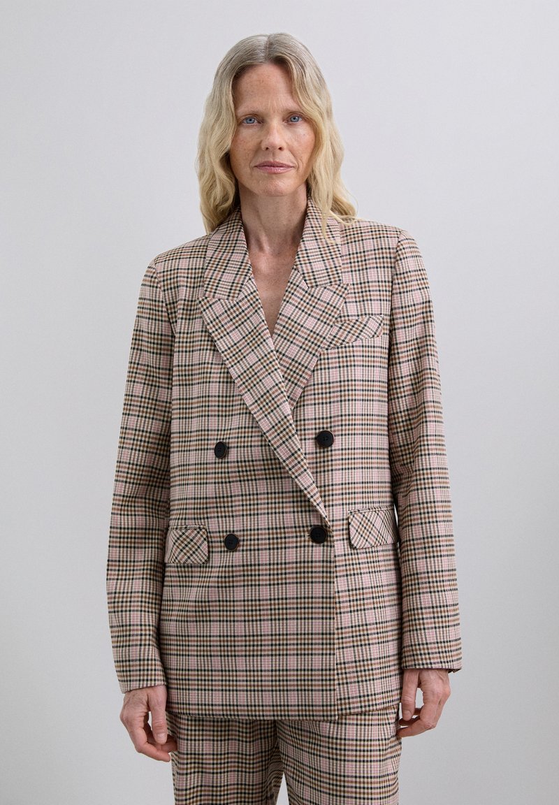 Double-breasted plaid blazer in pink, green, and cream. Features black buttons, notch lapels, and front pockets. Smooth fabric with a tailored fit.