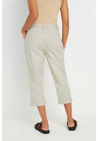 Beige cropped trousers with rolled cuffs, featuring a classic waistband, dual back pockets, and made from lightweight cotton fabric.