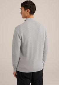 Grauer Strickpullover mit hohem Kragen, strukturierter Oberfläche, gerippten Bündchen und Saum. Entworfen in lockerer Passform, von hinten gezeigt.