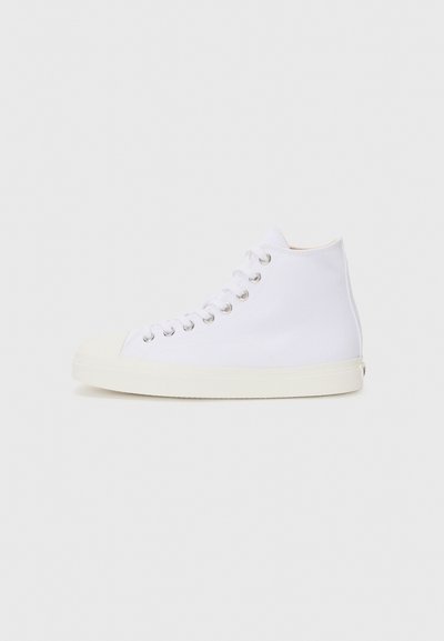 Sneaker alb din pânză, model înalt, cu vârf rotund, ochiuri metalice și talpă din cauciuc crem. Textură netedă cu detalii de design minime.