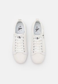 Vita canvas sneakers med en slät finish, med rund tå, snörningsdesign och subtil logotypdetalj på tungan och sidan.