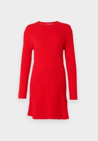 Robe-pull en maille côtelée rouge à manches longues avec un col rond et une silhouette ajustée, présentée sur un fond blanc uni.